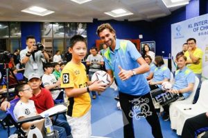 Grade 7 student Sung Zhou poses with Ruslan. Sung and the other students all received a signed football from the 7 soccer stars.