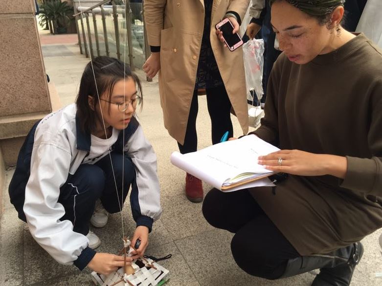 Wuhan students working on egg drop containers by reviewing notes