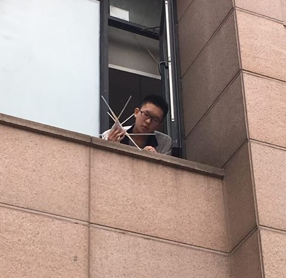 Wuhan student preparing to release egg drop container from campus window