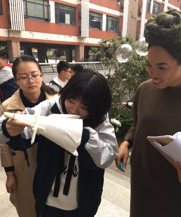 Wuhan students placing raw egg into crafted egg drop container
