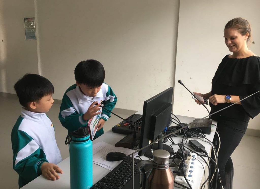 Ms. Hilt helps her students conduct a radio show segment