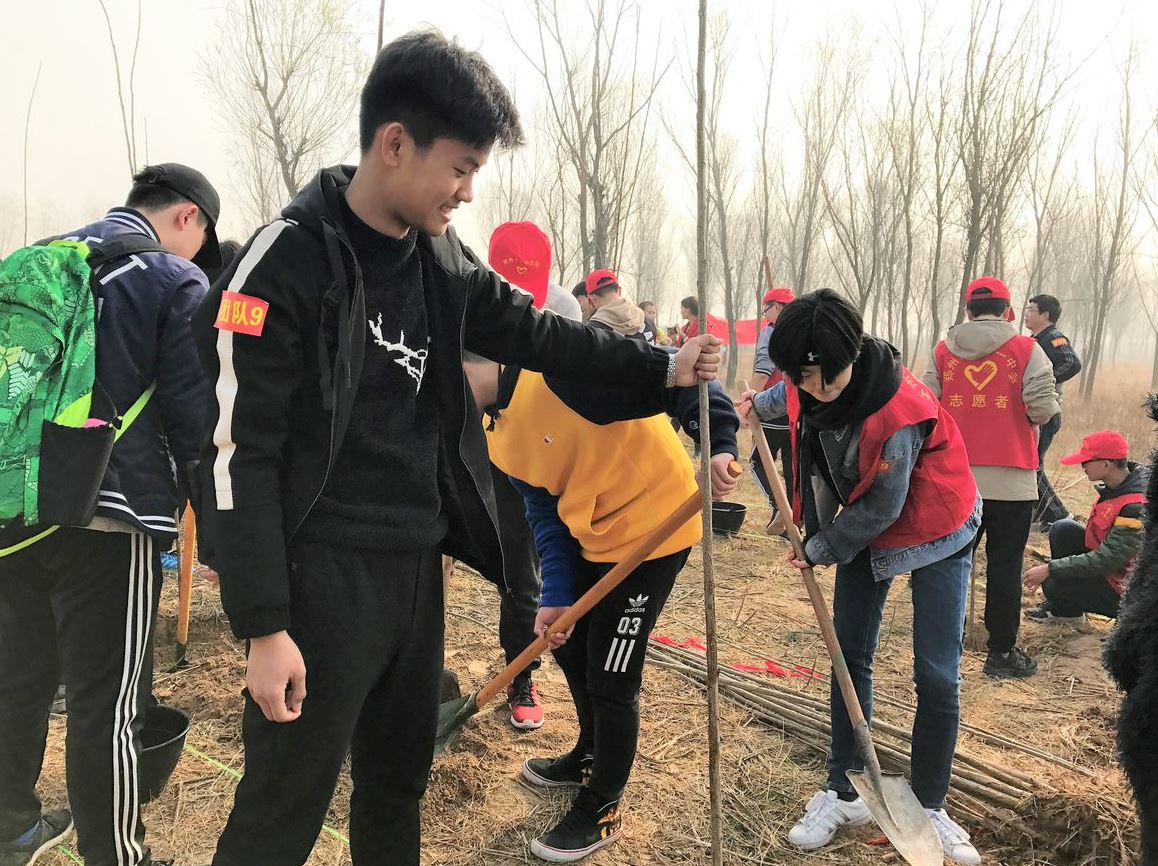 Zhengzhou students planting trees in the community for Arbor Day